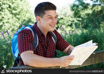 Man Hiking In Countryside With Map