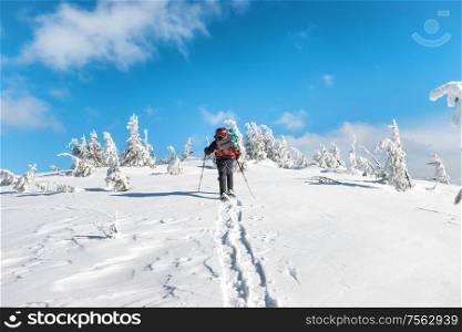 Man hiking on snow in winter mountains