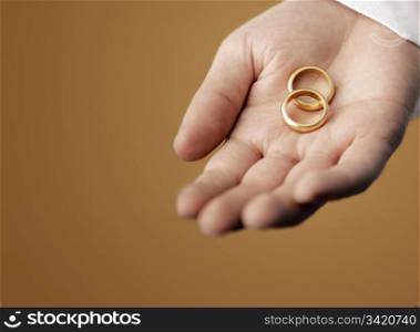 Man holding 100 year old gold wedding rings in his hand.