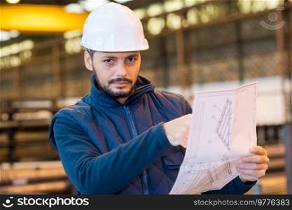 man holding a blueprint to manufacture