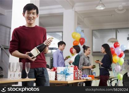 Man Holding A Bottle Of Champagne At Office Party