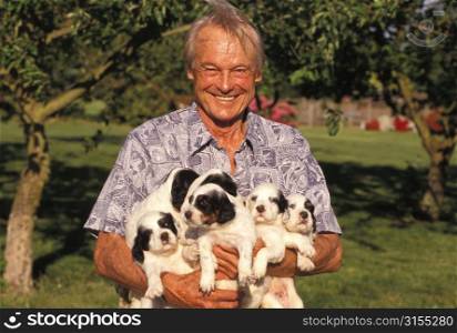 Man Holding a Bunch of Puppies