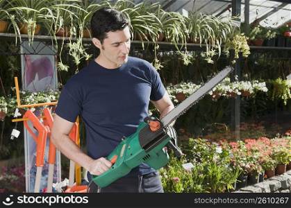 Man holding a chainsaw in a hardware store