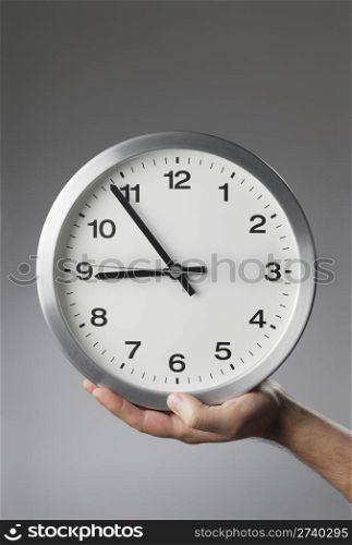 Man holding a clock in his hand.