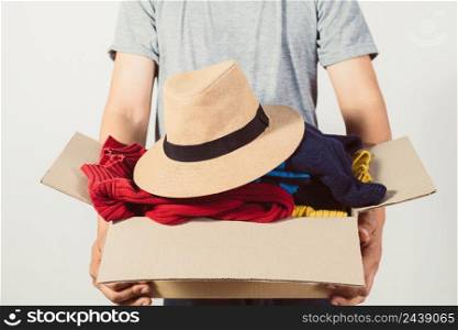 man holding a crate of second-hand clothes unused clothes