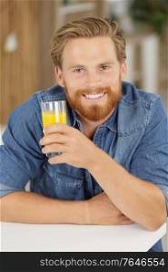 man holding a glass of orange juice