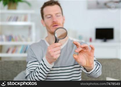 man holding a magnifying glass and magnifying viewer ring