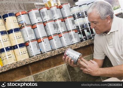 Man holding a paint can in a hardware store