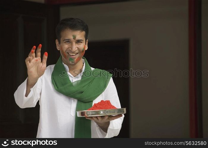 Man holding a plate of gulal