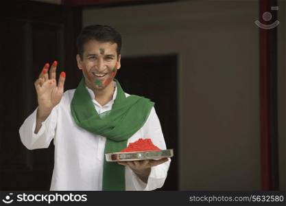 Man holding a plate of gulal