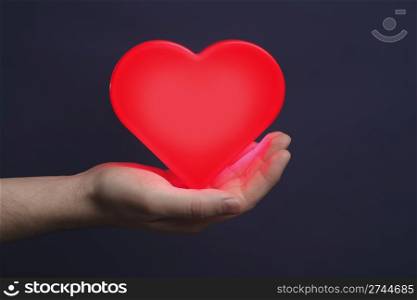 Man holding a red glowing heart on his palm.