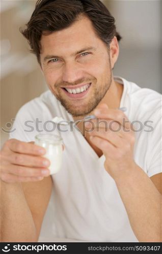 man holding a spoon of yogurt