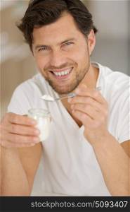 man holding a spoon of yogurt