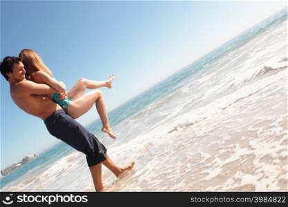 Man holding a woman on a beach