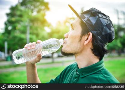 Man holding and drinking water after jogging,water and drink