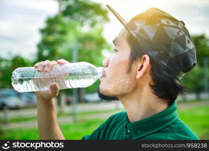 Man holding and drinking water after jogging,water and drink