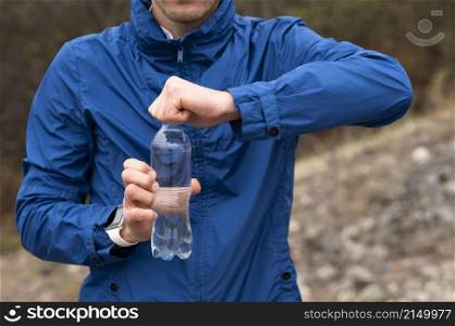 man holding bottle water nature