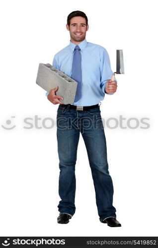 Man holding breeze block and trowel