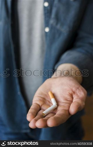 man holding broken cigarette his hand