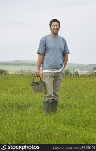 Man holding bucket in field, portrait