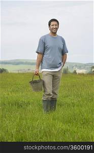Man holding bucket in field, portrait