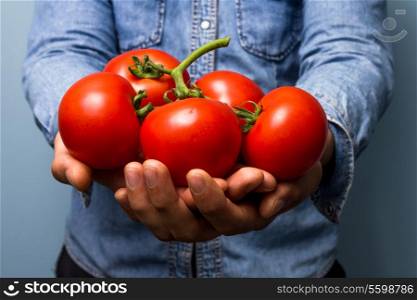 Man holding bunch of big tomatoes