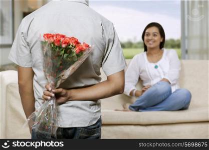 Man holding bunch of flowers behind back