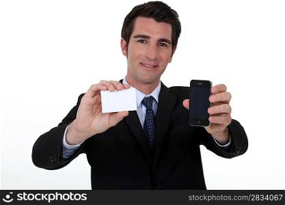Man holding business-card and mobile telephone