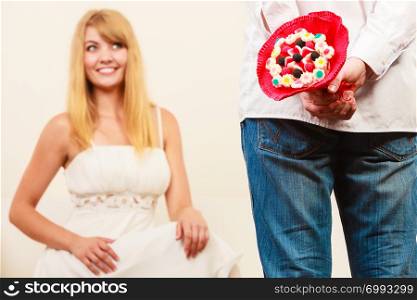 Man holding candy bunch flowers. Boyfriend with surprise present gift for woman girlfriend. Happy couple. Love.. Man giving woman candy bunch flowers. Love.