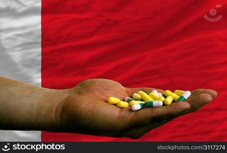 man holding capsules in front of complete wavy national flag of bahrain symbolizing health, medicine, cure, vitamines and healthy life