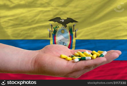 man holding capsules in front of complete wavy national flag of ecuador symbolizing health, medicine, cure, vitamines and healthy life