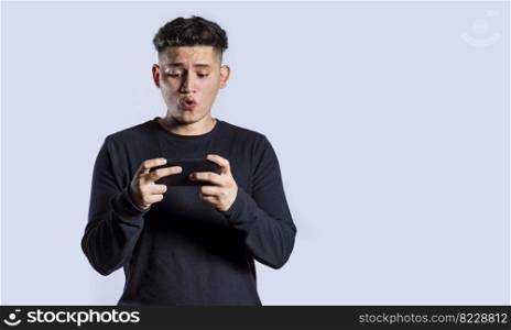 Man holding cell phone horizontally, Guy gasping and playing games on his smartphone