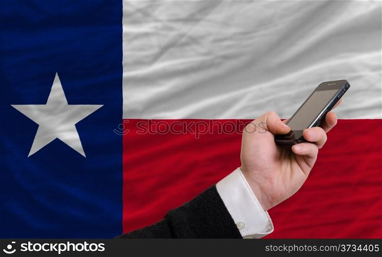 man holding cell phone in front flag of us state of texas symbolizing mobile communication and telecommunication