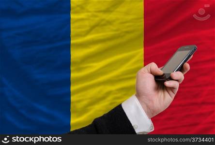 man holding cell phone in front national flag of romania symbolizing mobile communication and telecommunication