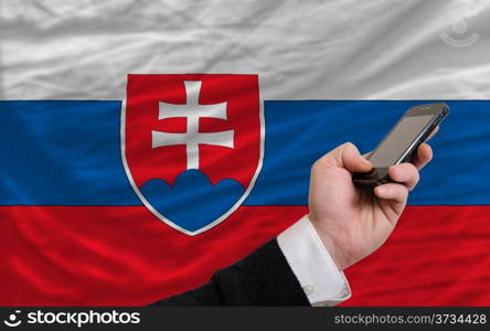 man holding cell phone in front national flag of slovakia symbolizing mobile communication and telecommunication