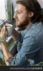 man holding coffee cup close up