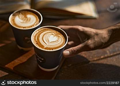 Man holding coffee cup with latte art, Selective focus. Man holding coffee cup with latte art