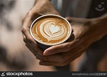 Man holding coffee cup with latte art, Selective focus. Man holding coffee cup with latte art,