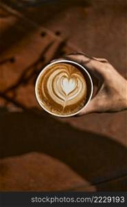 Man holding coffee cup with latte art, Selective focus. Man holding coffee cup with latte art,