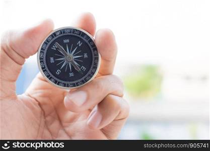 man holding compass on blurred background. for activity lifestyle outdoors freedom or travel tourism and inspiration backpacker alone tourist travel or navigator image.
