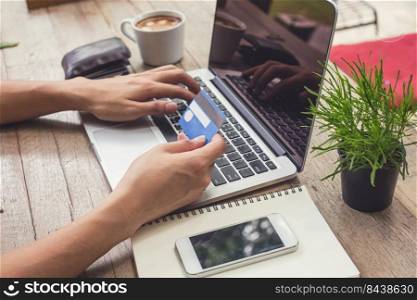 Man holding credit card and using laptop. Online shopping