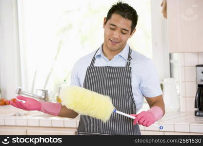 Man Holding Duster And Wearing Rubber Gloves