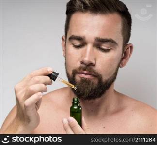 man holding face oil bottle close up