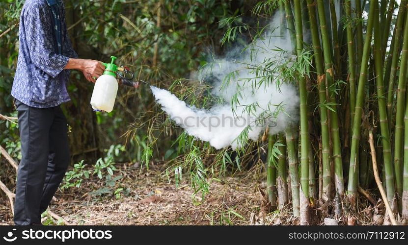 Man holding fogging to eliminate mosquito for preventing spread dengue fever and zika virus in the bamboo forest Mosquito spray