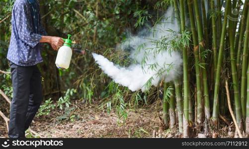 Man holding fogging to eliminate mosquito for preventing spread dengue fever and zika virus in the bamboo forest Mosquito spray