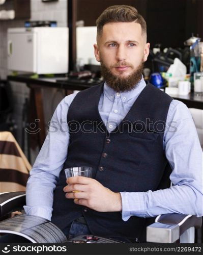 man holding glass whiskey barber shop