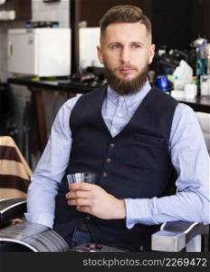 man holding glass whiskey barber shop