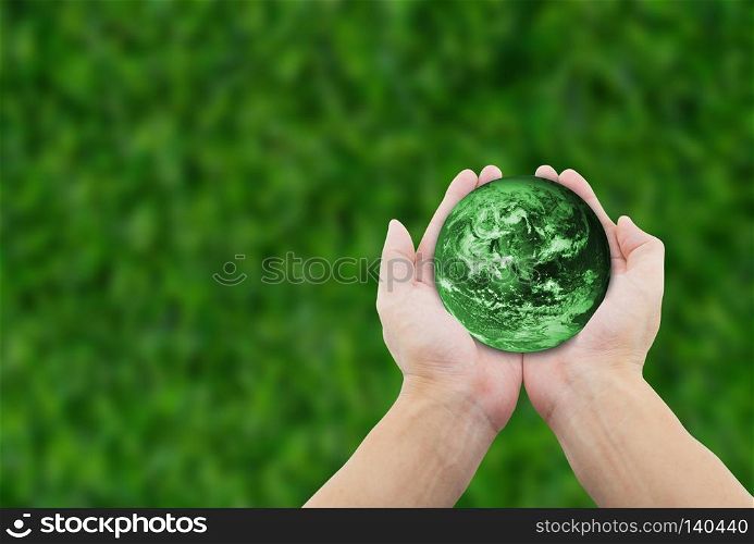 man holding globe with hands on grass background. Elements of this image furnished by NASA