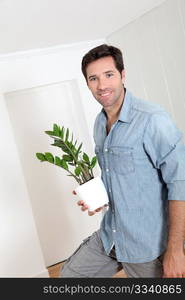 Man holding green plant in new house