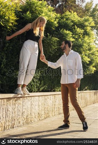 man holding hands with his wife while having walk